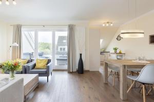 een woonkamer met een tafel en een eetkamer bij Baltic Sea Lodge Wohnung 5 in Scharbeutz