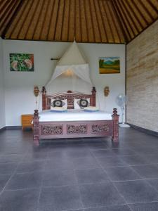 a bed with a canopy in a room at Giri Carik in Sidemen