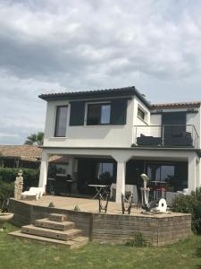 ein großes weißes Haus mit einer Terrasse davor in der Unterkunft Maison de vacances en Camargue in Marsillargues