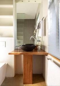 um balcão de casa de banho com um lavatório e um espelho em Seaview Apartment in Muizenberg em Muizenberg