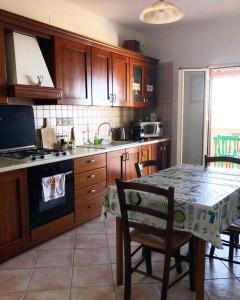 - une cuisine avec des placards en bois, une table, une table et des chaises dans l'établissement LA Casa il carretto, à Agrigente