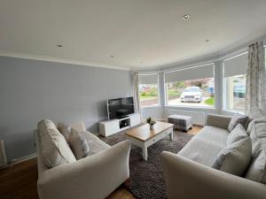 a living room with two couches and a tv at Dragonfly - HOT TUB luxury two bedroom cottage in Cellardyke