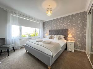 a bedroom with a large bed and a window at Dragonfly - HOT TUB luxury two bedroom cottage in Cellardyke