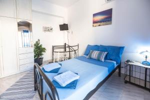 a bedroom with a blue bed and a desk at Jaana & Akis Holiday Home 1&2, Haraki in Haraki