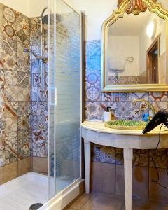 bagno con doccia, lavandino e specchio di LA Casa il carretto a Agrigento