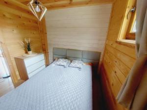 a small bedroom with a bed in a cabin at ZACISZE Domek na Kaszubach Brodnica Dolna z balią z jacuzzi in Brodnica Dolna