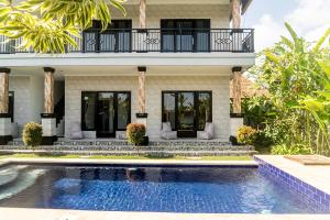 a house with a swimming pool in front of a house at Surf & Party - Hostel Somewhere Else in Canggu