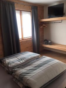 um quarto com uma cama, uma janela e uma televisão em Chrys appartamenti em Valfurva
