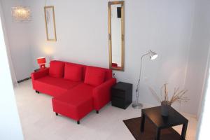 a living room with a red couch and a table at Skion Palace Beach Hotel-Bungalows & Boutique Hotel in Nea Skioni