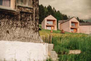 eine Gruppe von Häusern auf einem Feld mit Bäumen in der Unterkunft Peterhof Chalets in Batschuns