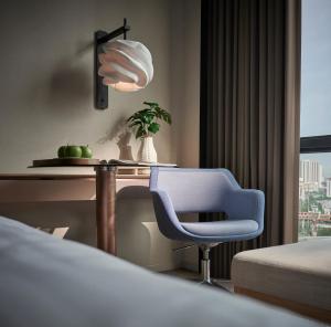 a bedroom with a bed and a desk and a chair at Amari Kuala Lumpur in Kuala Lumpur