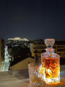 uma garrafa de vidro numa mesa com um copo de vidro em WUKELA APARTMENTS em Atenas