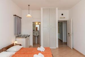 sypialnia z 2 łóżkami oraz łazienka z umywalką w obiekcie Esperides w mieście Tinos