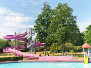 a water slide in a park with a pool at Villa Blue Sky in Heinkensand