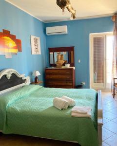 una camera con letto verde e pareti blu di LA Casa il carretto a Agrigento
