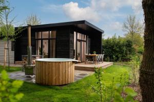 a black tiny house with a table in a yard at Vakantiepark Mölke in Zuna