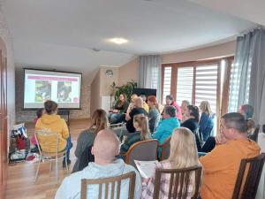 WojniczにあるAris Pokoje Gościnneのプレゼンテーションのために部屋に座っている人々のグループ
