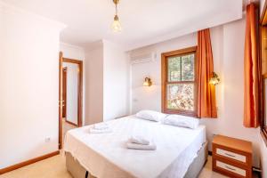 una camera da letto con un letto con due asciugamani sopra di Kybele Sea view a Kaş