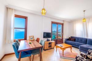 un soggiorno con un divano blu e un tavolo di Kybele Sea view a Kaş