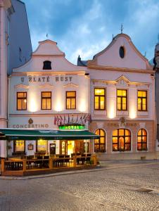 a large white building with tables in front of it at Hotel Concertino Zlatá Husa in Jindřichŭv Hradec