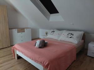 ein Schlafzimmer mit einem Bett mit einer rosa Decke in der Unterkunft Apartmani Timon in Bol