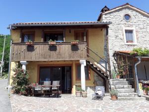 a building with a balcony and a table and chairs at Hostel Xaxid in Črni Kal