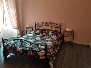 - une chambre dotée d'un lit avec un couvre-lit floral dans l'établissement LA MAISON DE LOLA, à Port-en-Bessin-Huppain