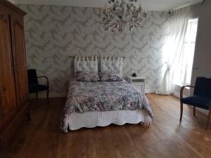 sypialnia z łóżkiem i ścianą w obiekcie LA MAISON DE LOLA w mieście Port-en-Bessin-Huppain