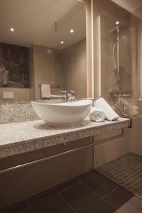 a bathroom with a white sink and a shower at Das Steinmüller Hotel in Gummersbach