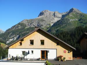 a barn with a mountain in the background at Haus Gaudenz in Warth am Arlberg