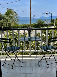 a table and chairs on a balcony with a view of the ocean at Cosy Apartment With Sea View Close To The Beach in Nikiana