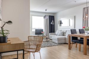 a living room with a white couch and a table at Arctic Railway City Suite in Rovaniemi