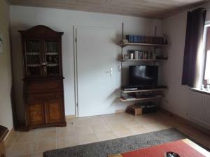 a living room with a television and a door with a shelf at Ferienwohnung Hilde Schneider in Kappeln