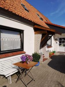 a table with flowers on it next to a house at Ferienwohnung Hilde Schneider in Kappeln