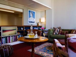 uma sala de estar com uma mesa e um sofá em Bell Hill Apartments em Dunedin