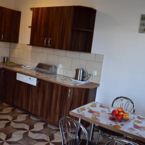WojniczにあるAris Pokoje Gościnneのキッチン(木製キャビネット、フルーツ付きのテーブル付)