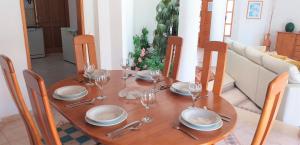a wooden table with plates and wine glasses on it at Vila Rosada in Quarteira