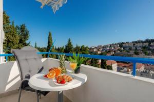 a table with a plate of fruit on a balcony at Apartment Sunset free parking in Dubrovnik