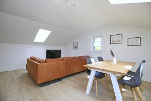a living room with a table and a couch at Strandvilla Meeresblick Wohnung 07 in Boltenhagen