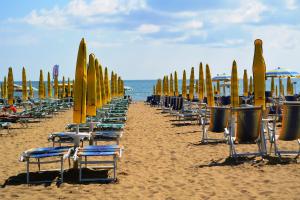 a row of chairs and surfboards on a beach at Villa Serena in Lido di Jesolo