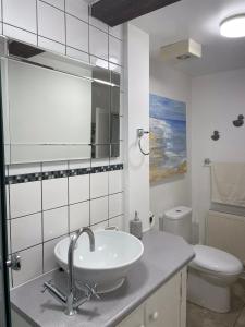 a white bathroom with a sink and a toilet at Chiddy Nook Cottage in Chideock