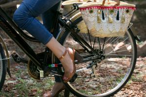 Una donna va in bicicletta con un cesto di Giardini Mon Plaisir a Trapani