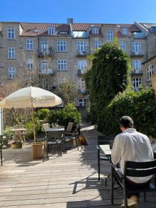 a man sitting on a bench in front of a building at SOFS boutique hotel in Aarhus