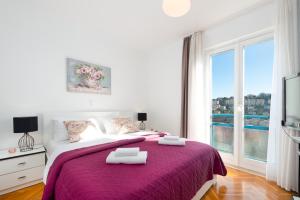 a bedroom with a large bed with two towels on it at Apartment Sunset free parking in Dubrovnik