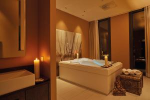 a bathroom with a tub and a sink with two candles at HYPERION Hotel Hamburg City, Trademark Collection by Wyndham in Hamburg +107 photos