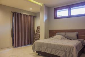 a bedroom with a large bed and a window at Villa Dago Pakar Bandung in Bandung +8 photos