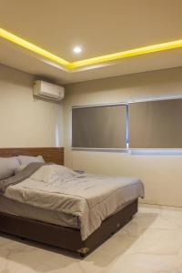 a bedroom with a bed and a large window at Villa Dago Pakar Bandung in Bandung
