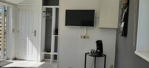 a living room with a tv on a wall at 't Bûtefjild in De Broek