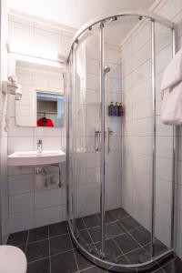 a bathroom with a shower and a sink at Birkebeineren Hotel & Apartments in Lillehammer +42 photos