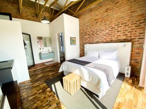 a bedroom with a bed and a brick wall at Eden on Edwards - no more loadshedding! in Knysna